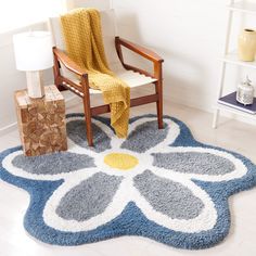 a blue and white rug with a flower design on the floor next to a chair