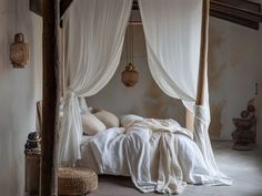 a bed with white sheets and pillows in a room