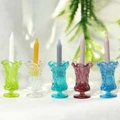 four glass candles are lined up in a row