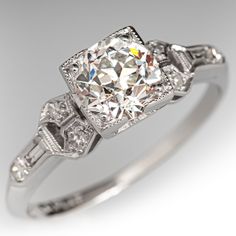 This lovely architectural circa 1920s Art Deco ring is centered with one (1) old European cut diamond, weighing 0.95 carats, that is prong set in a square frame with milgrain edging. Each shoulder is accented with three (3) bead set round single cut diamonds, and one (1) bezel set baguette cut diamond. The shoulders also have milgrain edges. The ring measures 6.2mm at the top, rises 6.1mm above the finger, tapering to 1.3mm wide and 1.0mm thick at the base of the shank.  The ring is crafted in platinum and is currently a size 5.  One of the baguette diamonds has a tiny corner chip that cannot be seen while worn. Luxury Single Diamond Art Deco Ring, Luxury Art Deco Diamond Ring With Prong Setting, Luxury Diamond White Sapphire Art Deco Ring, Luxury Art Deco Platinum Halo Ring, Luxury Art Deco Ring With Polished Finish, 3 Diamond Ring Settings Square, Luxury Art Deco Princess Cut Diamond Ring, Luxury Art Deco White Sapphire Ring, Luxury Vintage Baguette Cut Diamond Ring