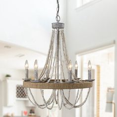 a chandelier hanging from the ceiling in a white room with candles on it