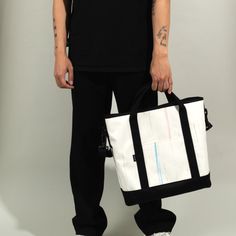 a man holding a black and white tote bag