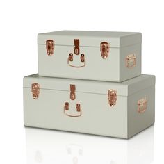 two white suitcases sitting side by side on top of each other with gold handles