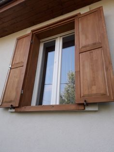 an open window with wooden shutters on the outside