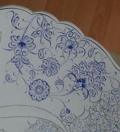 an ornate blue and white plate with flowers on it