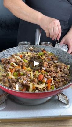 a person cooking food in a pan on top of a stove