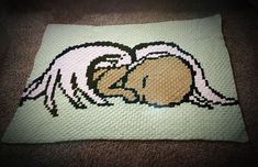 a crocheted blanket with a dog laying on it's side and its head in the ground