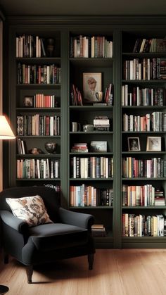 a chair in front of a bookshelf filled with lots of bookcases