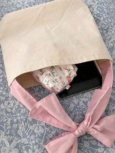 a pink bow tied around an open box