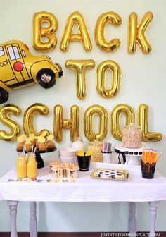 the back to school party table is set up with balloons