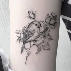 a bird sitting on top of a branch with flowers