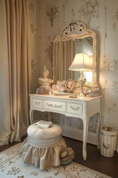 a white dressing table with a mirror, stool and lamp on it in a room