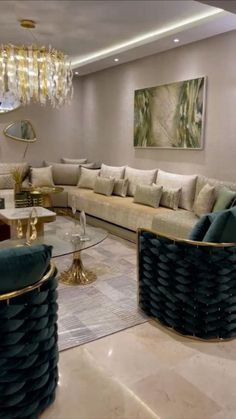 a living room filled with furniture and a chandelier hanging above the couches