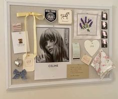 a white frame with pictures and magnets attached to the wall next to a bow