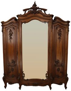 an ornate wooden armoire with mirror on it's top and bottom paneling