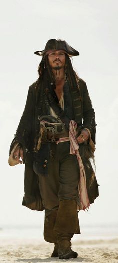 a man dressed as captain jack sparrow on the beach