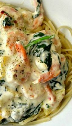 pasta with shrimp and spinach sauce in a white bowl