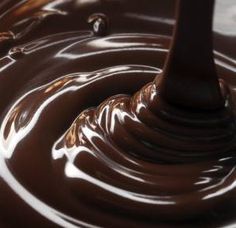 melted chocolate is being stirred by a spoon