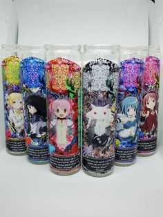 six different colored candles with anime characters on them