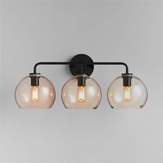 three light fixture with glass globes and black metal frame on grey wallpaper background