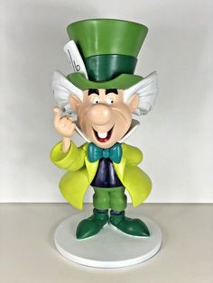 a green and white statue with a top hat on it's head