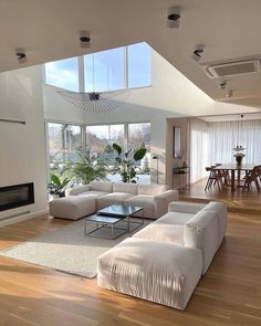 a living room with white furniture and large windows