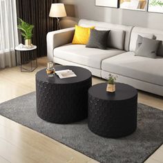 two black tables sitting on top of a rug in front of a white couch and chair