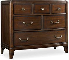 a wooden dresser with four drawers and two pulls on the bottom drawer, all in dark wood