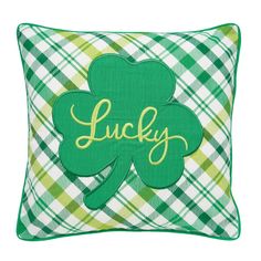 a green shamrock pillow with the word lucky on it