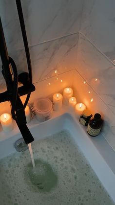 a bathtub filled with candles and soap