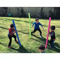 three young boys playing with plastic toys in the yard, one boy is holding a bat and two others are looking at it