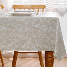 a table with a plate on it in front of some chairs and a wall behind it