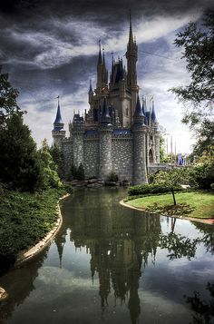 a castle is shown with its reflection in the water at disney world's magic kingdom