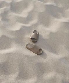 two sand shoes laying on top of a sandy beach