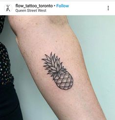 a small black pineapple tattoo on the arm