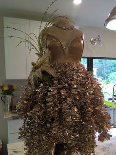 a mannequin made out of seashells in a kitchen