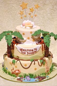 a three tiered cake decorated with animals and palm trees on top is shown in an instagram