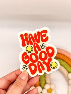 someone holding up a sticker that says have a good day