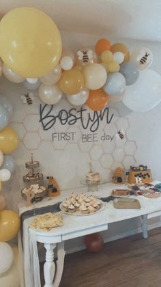 the dessert table is set up with honeycombs, cookies and balloons for this first bee day party