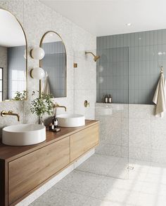 a bathroom with two sinks and mirrors on the wall, along with a bathtub