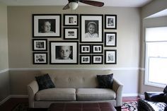 a living room filled with furniture and framed pictures on the wall above it's coffee table