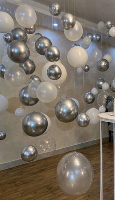 a table with a cake on it in front of some balloons hanging from the ceiling