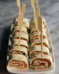 there are many rolls on the plate with toothpicks stuck in them and ready to be eaten