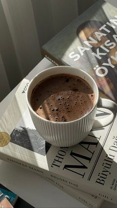 a cup of hot chocolate sitting on top of a book