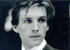 a black and white photo of a young man in a suit with a tie on