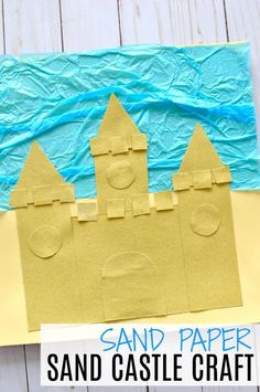 a sand castle made out of construction paper on top of a white wooden table with text overlay that says sand paper sand castle craft