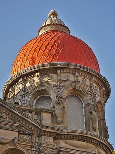 an ornate building with a red dome on top