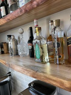 the shelves are full of liquor bottles and other alcohol on the counter top in this kitchen