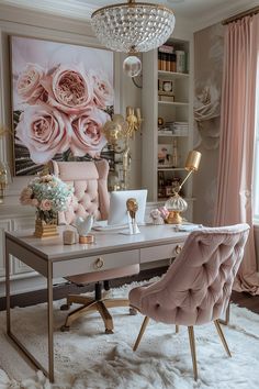 a pink chair and desk in front of a large floral wall hanging on the wall