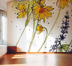 the wall has flowers painted on it and is next to a window with sunlight coming in